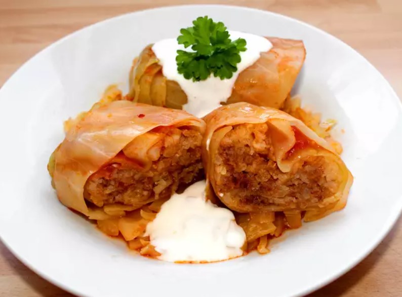 Stuffed cabbage rolls filled with minced meat and rice, with sour cream on top