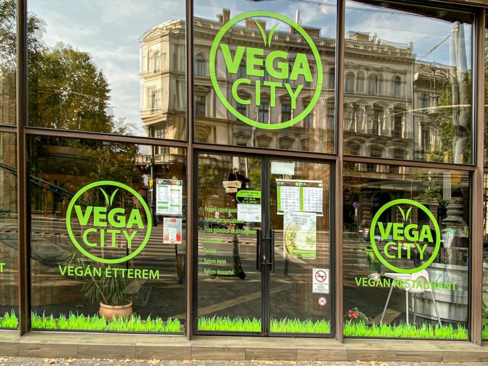 The glass-windowed entrance of Vega City vegan restaurant in Budapest