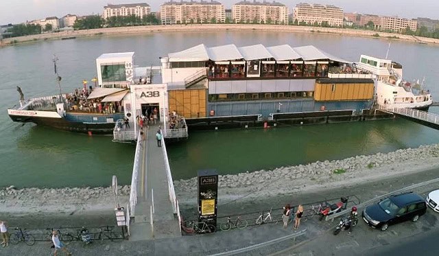 Exterior daytime view of the A38 cultural ship at its permanent dock in Buda