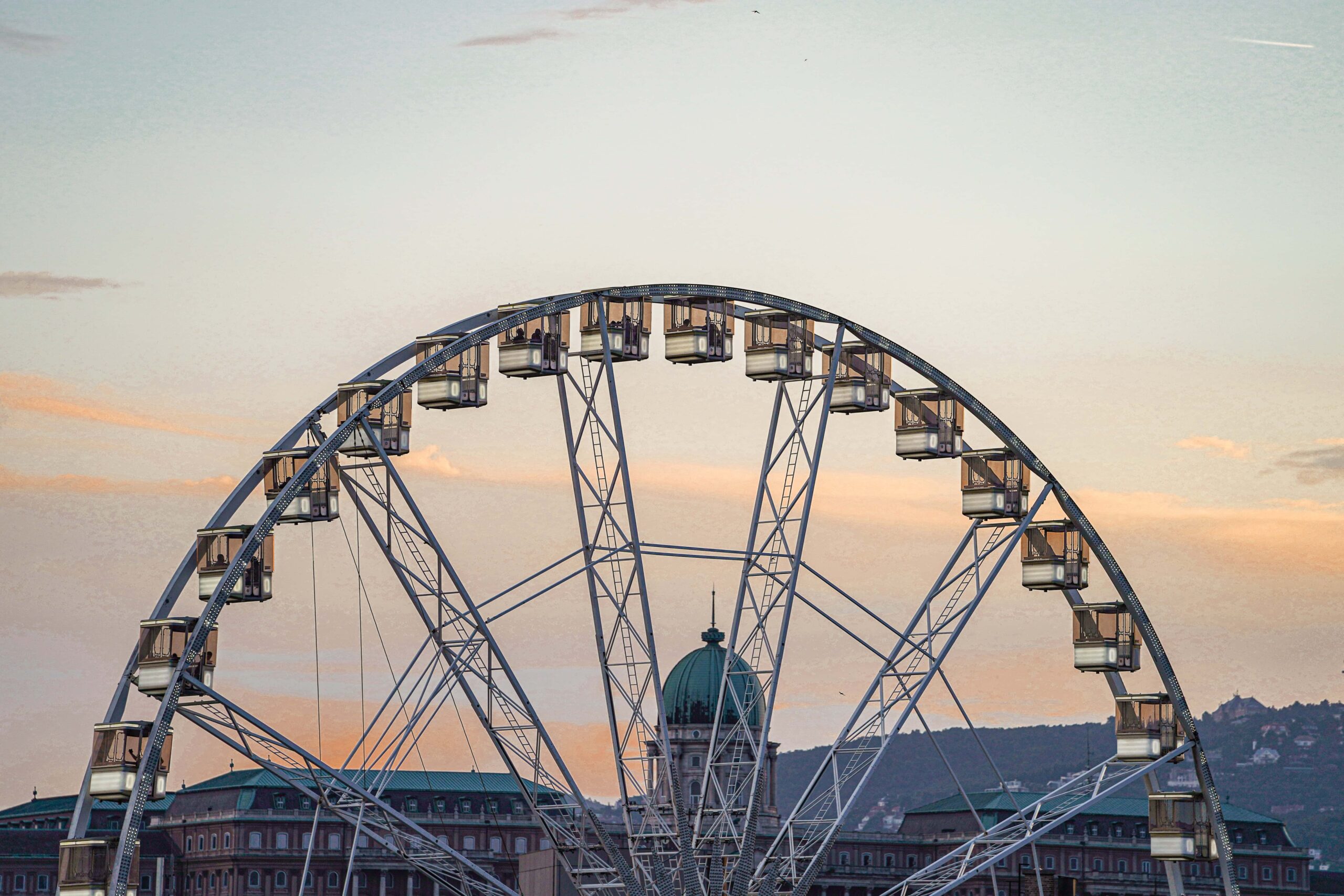 A high aerial view looking straight down at the Ferris wheel and the surrounding rooftops of downtown Budapest