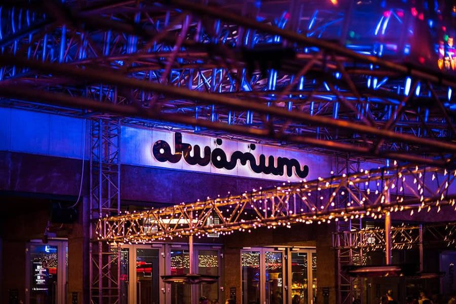 The brightly lit exterior and neon sign of Akvárium Klub at night