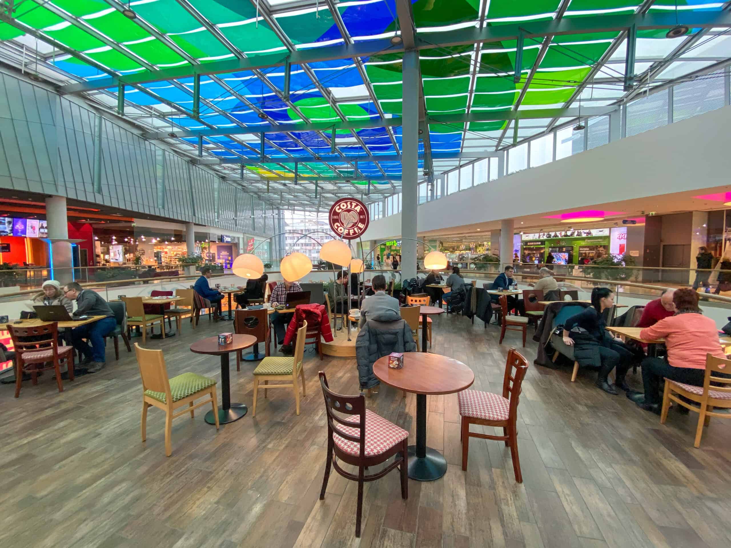The busy and modern food court seating area at Allee Mall in Budapest