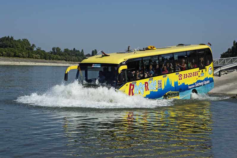 The yellow amphibious bus driving into the water creating a huge splash