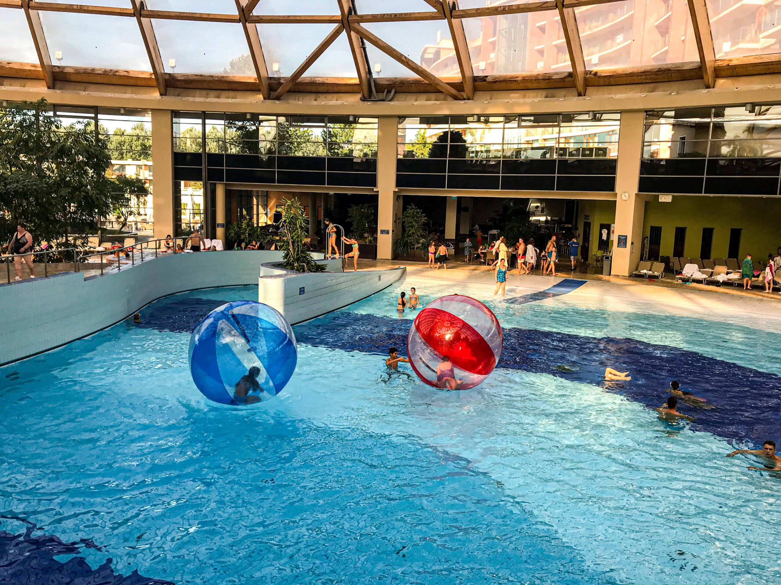 Happy visitors enjoying the exciting indoor wave pool under the glass dome of Aquaworld Budapest