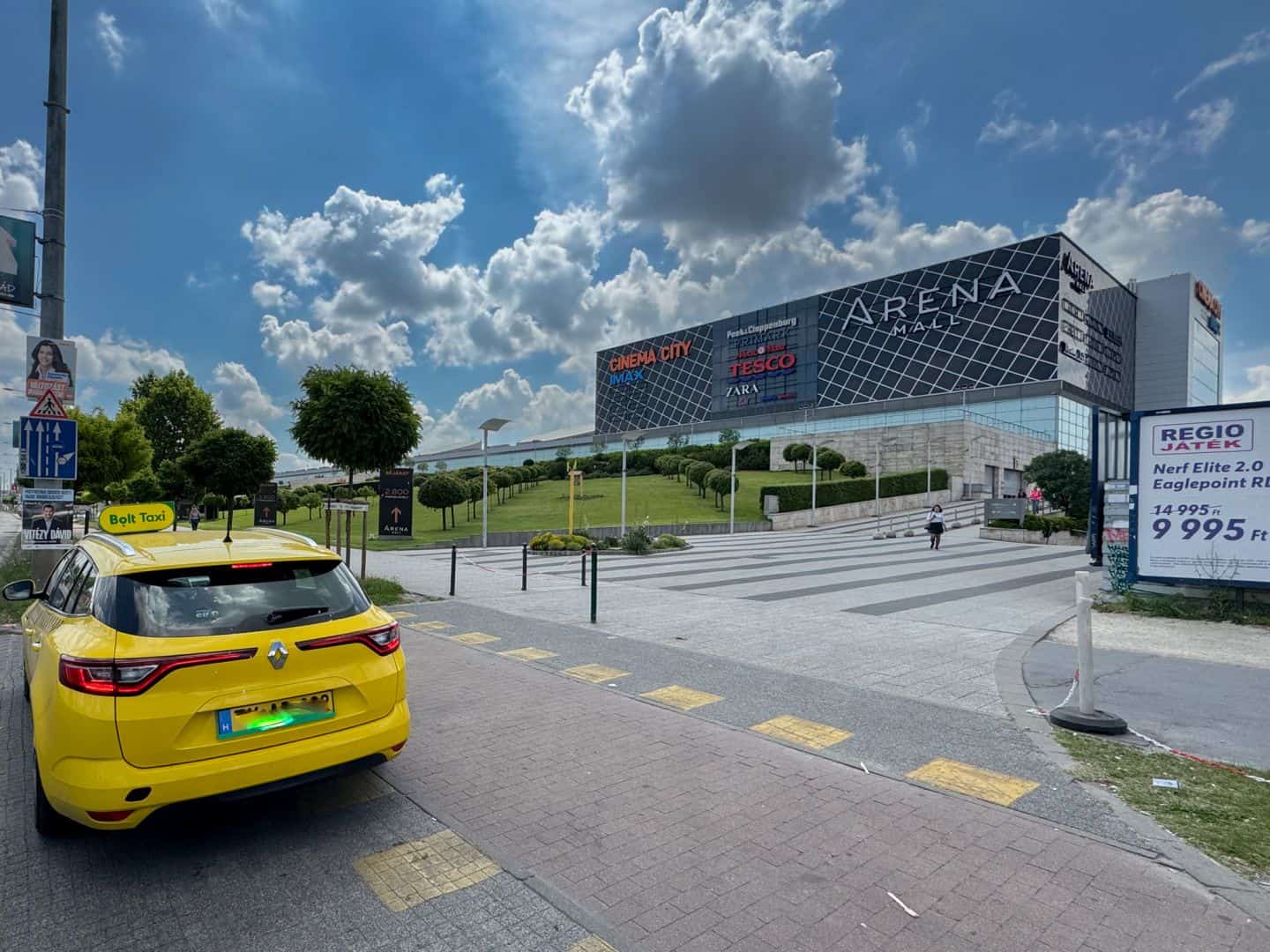 A yellow taxi parked outside the Arena Mall building where Primark is located