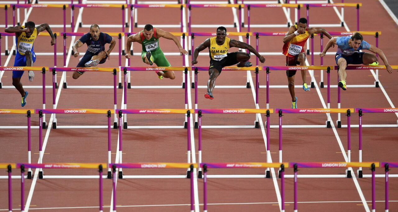 Athletes including a Hungarian runner jumping over hurdles at a World Championship race