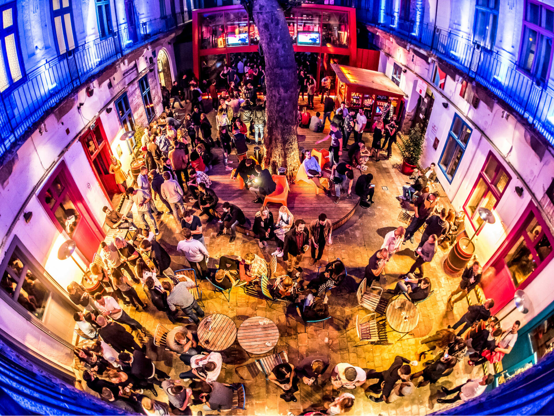 A lively night scene at a famous Budapest ruin bar courtyard