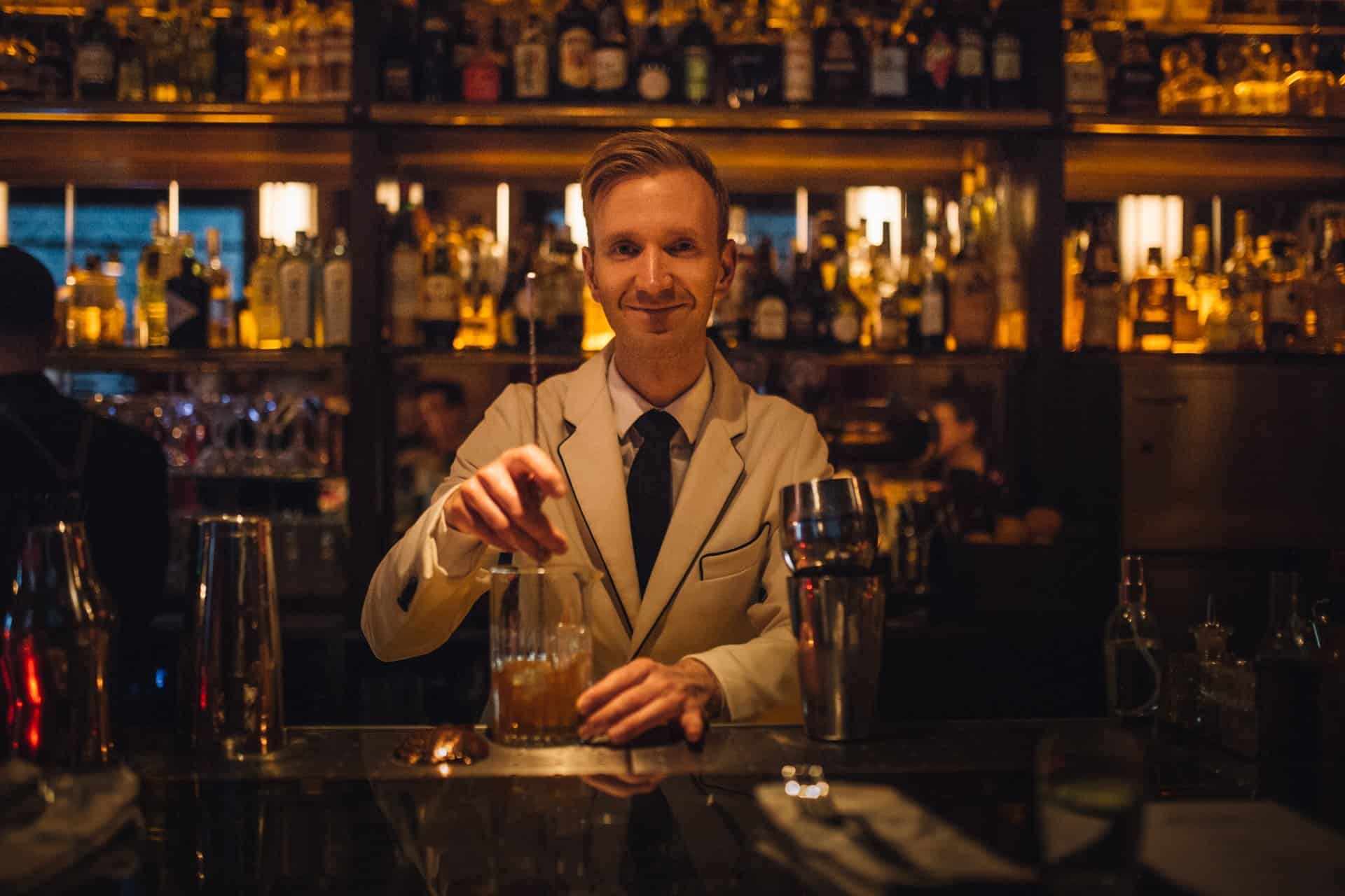 A skilled bartender preparing a craft cocktail at the Black Swan speakeasy in Budapest