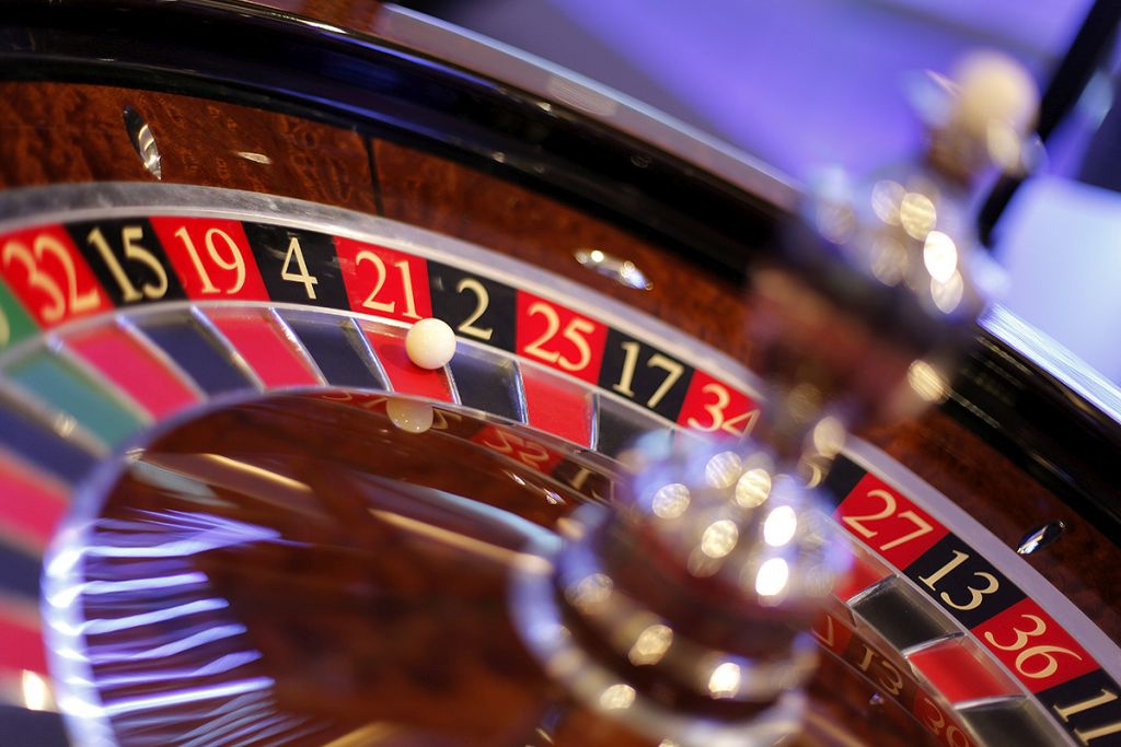 Overhead view of a dealer dealing hands at a green Blackjack table