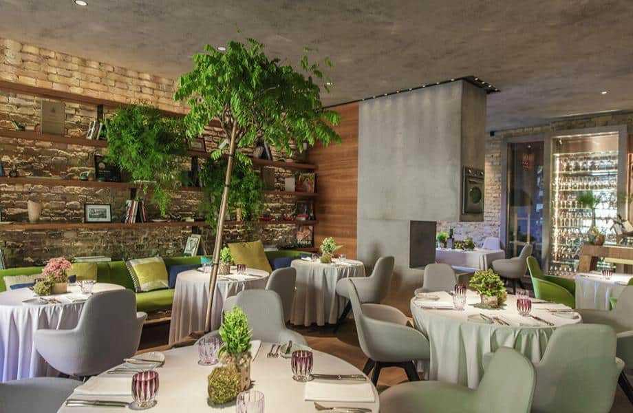 A vibrant elegantly modern culinary masterpiece surrounded by premium wines at Borkonyha