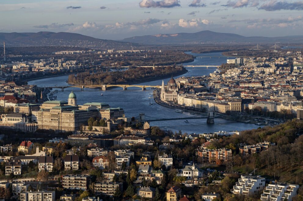 Panoramic aerial view of Budapest featuring the Danube, Chain Bridge, and Parliament