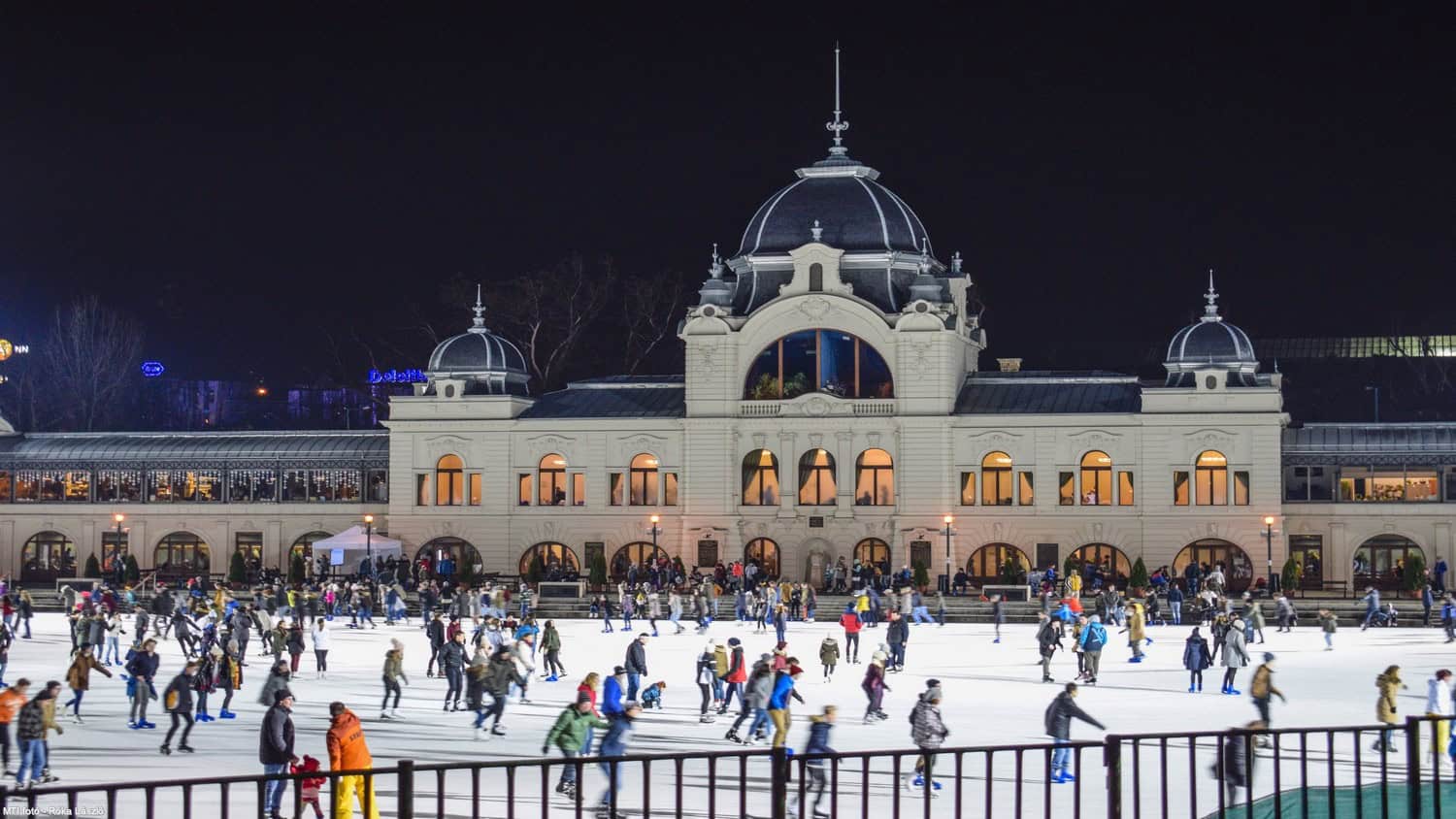 Crowds of people ice skating outdoors at the massive City Park Ice Rink during winter