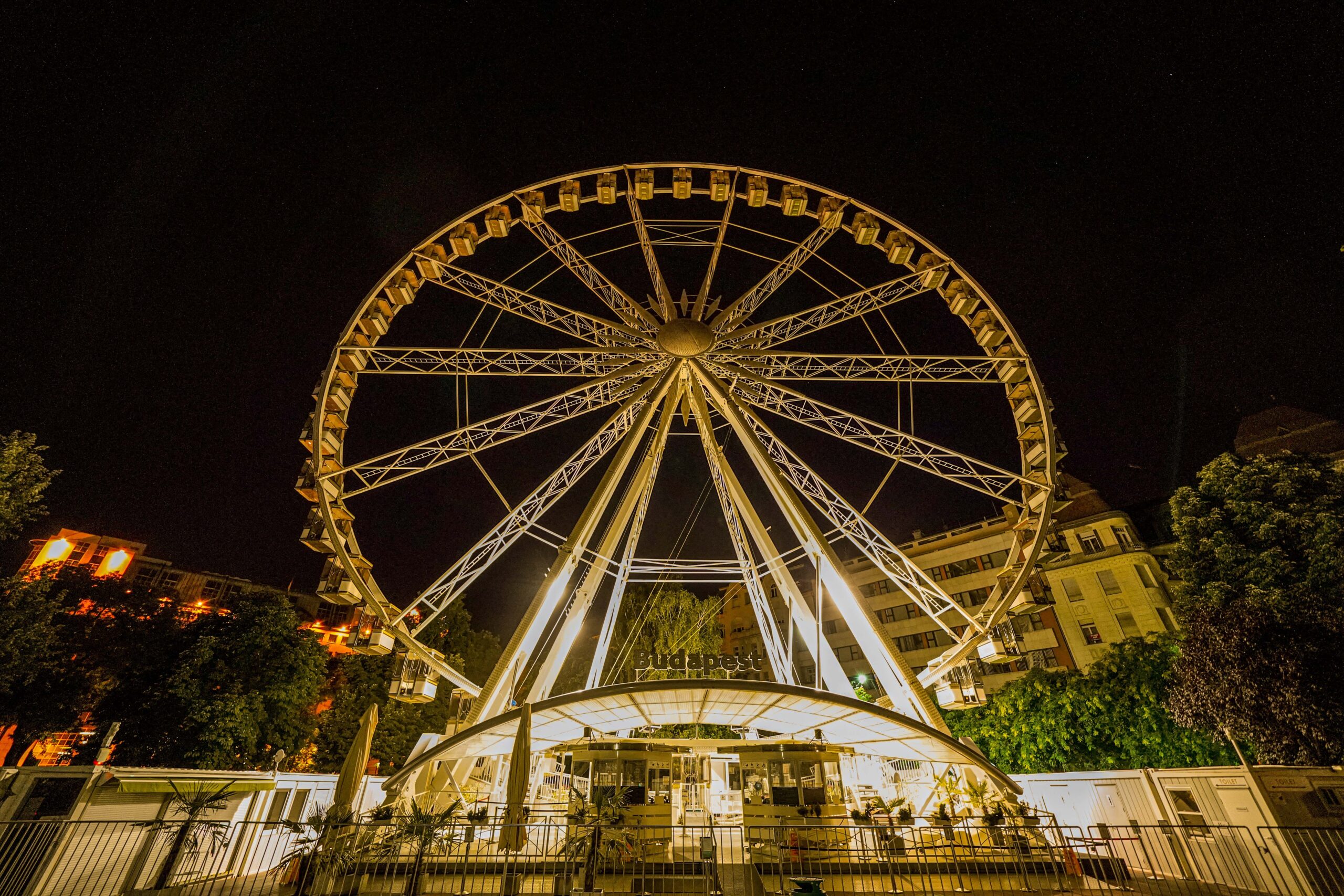 The Budapest Eye Ferris wheel glowing brilliantly with white LED lights against the night sky