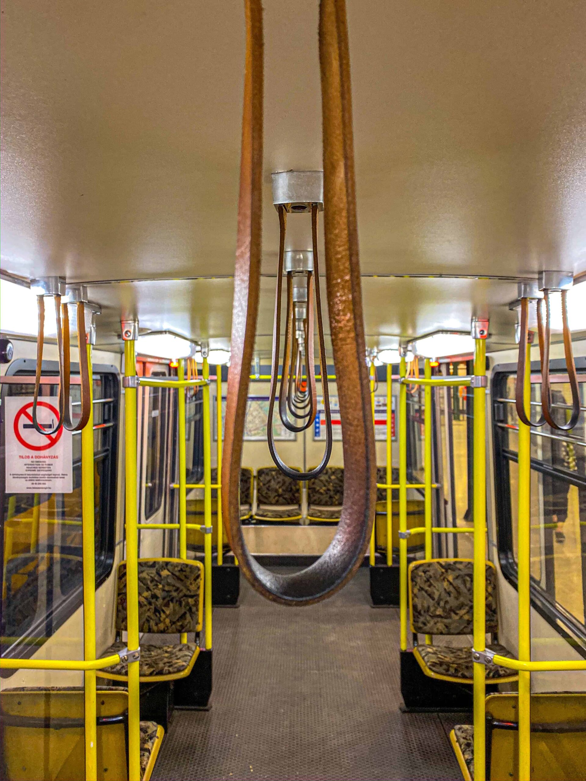 A deeply historic underground station featuring authentic green steel pillars and classic white tiles