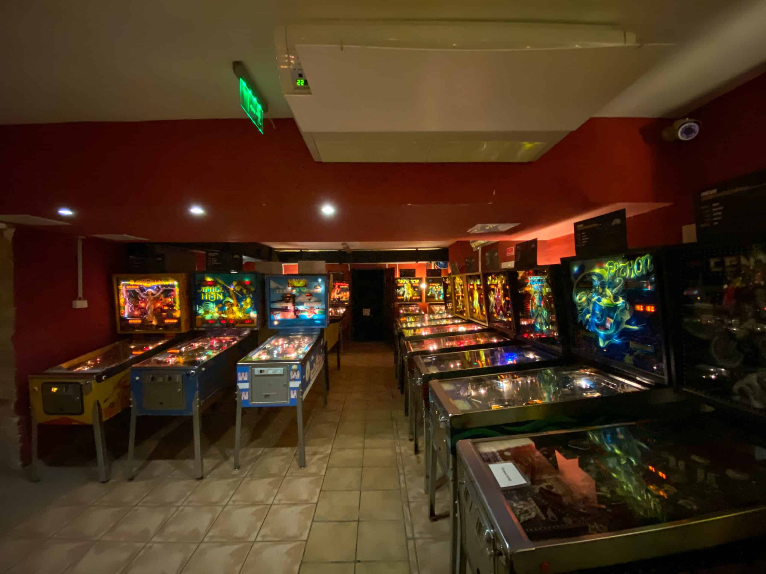 Rows of colorful vintage pinball machines and arcade games at the Budapest Pinball Museum.