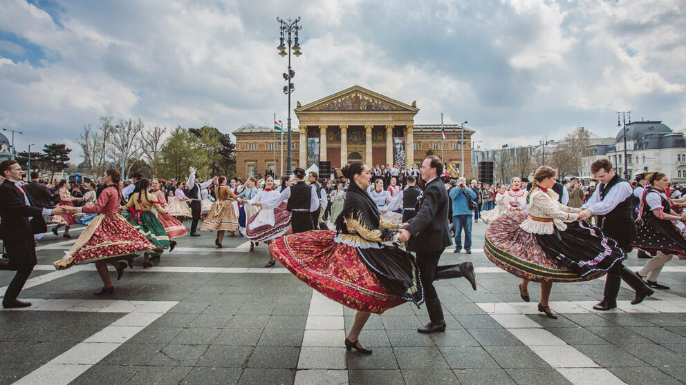 Traditional Hungarian folk dancers performing in front of the monuments at Heroes' Square