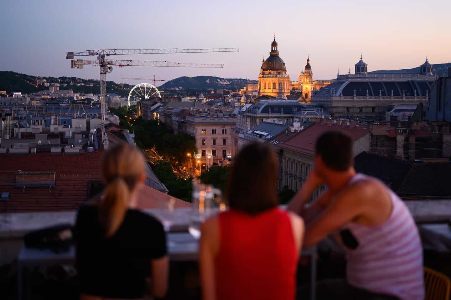 Romantic twilight view of St. Stephen's Basilica and Budapest Eye from an elevated terrace