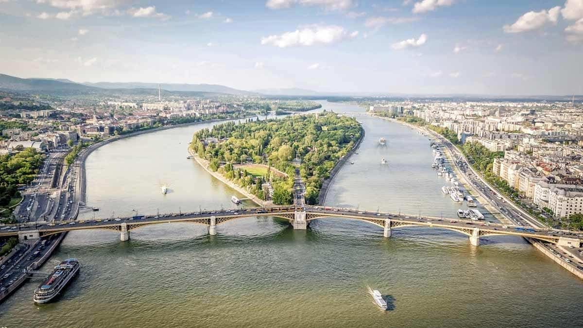 A commuter riding safely in a bright green, dedicated urban bike lane in Budapest