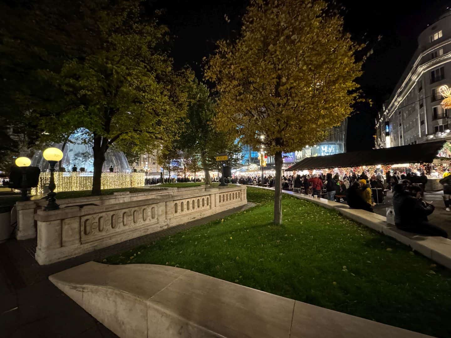 A festive winter Christmas market scene filled with bright holiday lights and wooden stalls