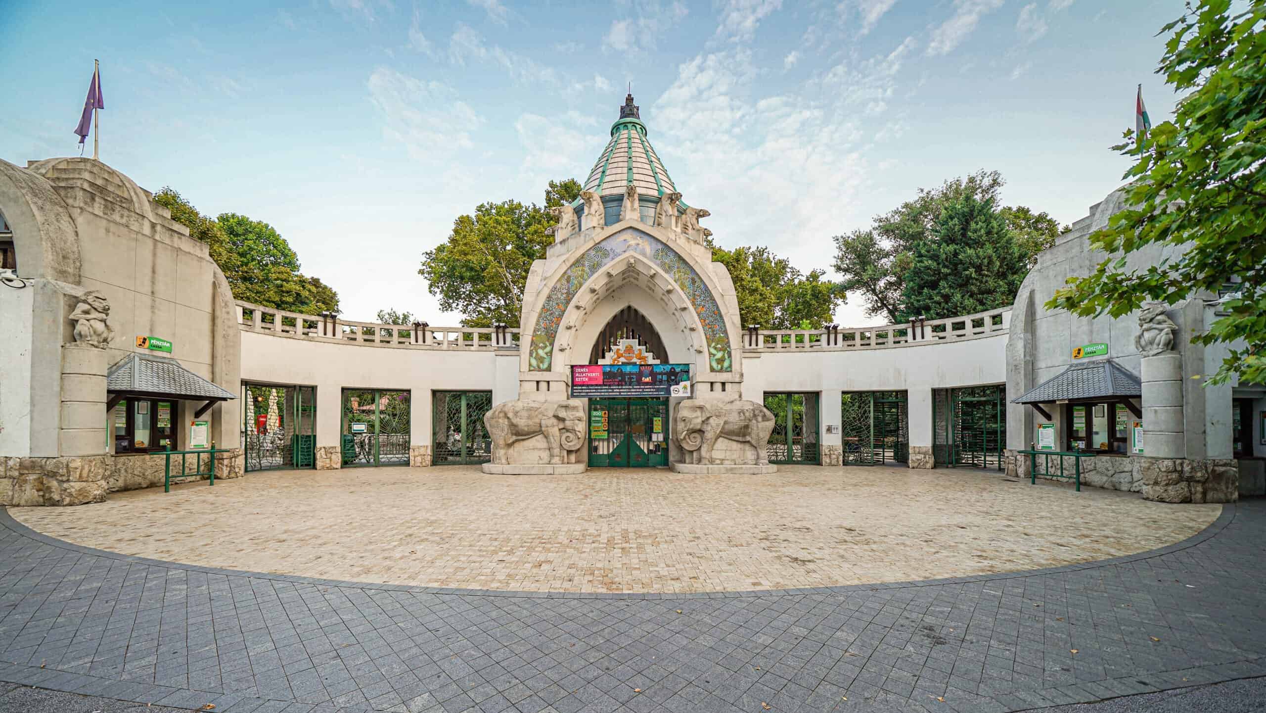 The ornate, historic stone archway entrance to the Budapest Zoo featuring carved elephants