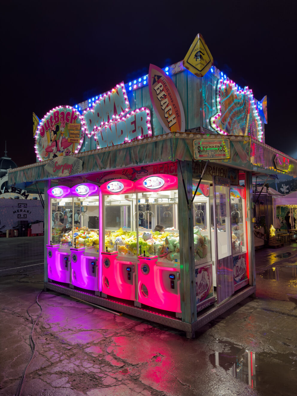 A classic carnival game booth where children fish for ducks to win plush toys