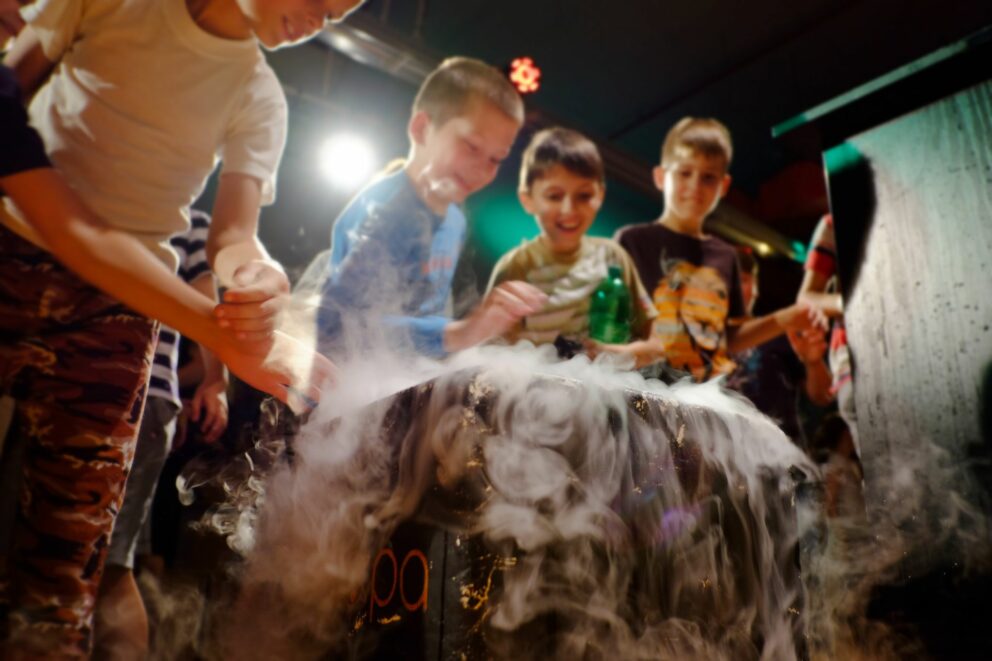 Families interacting with colorful hands-on science exhibits at the Center of Scientific Wonders