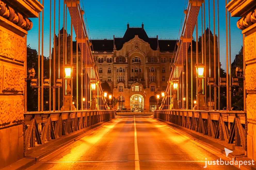 Looking down the illuminated Chain Bridge roadway toward Gresham Palace