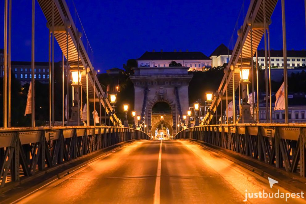 Pedestrians enjoying the wooden walkway along the side of the Chain Bridge