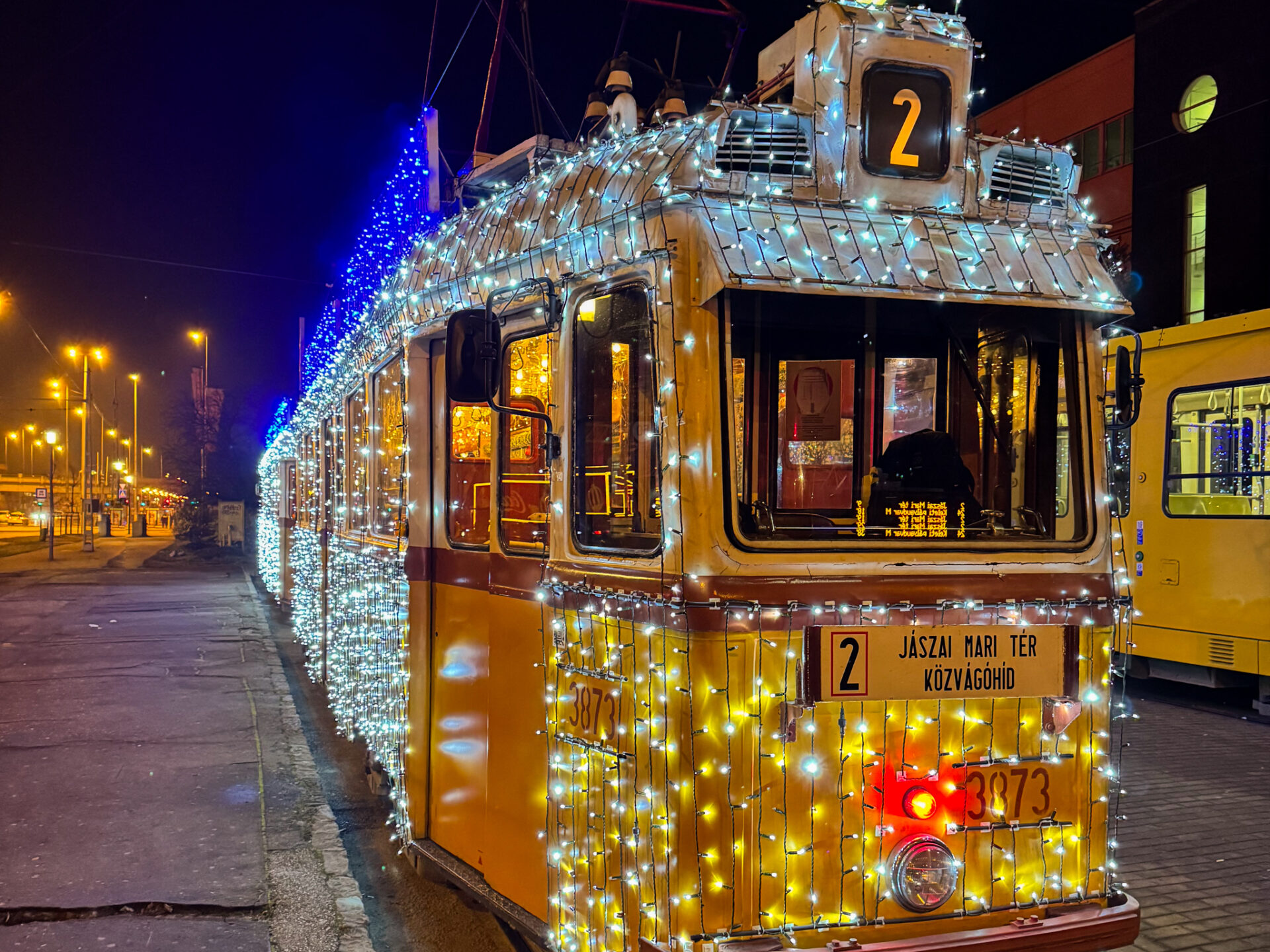The brightly glowing Christmas tram contrasting against the dark winter evening sky