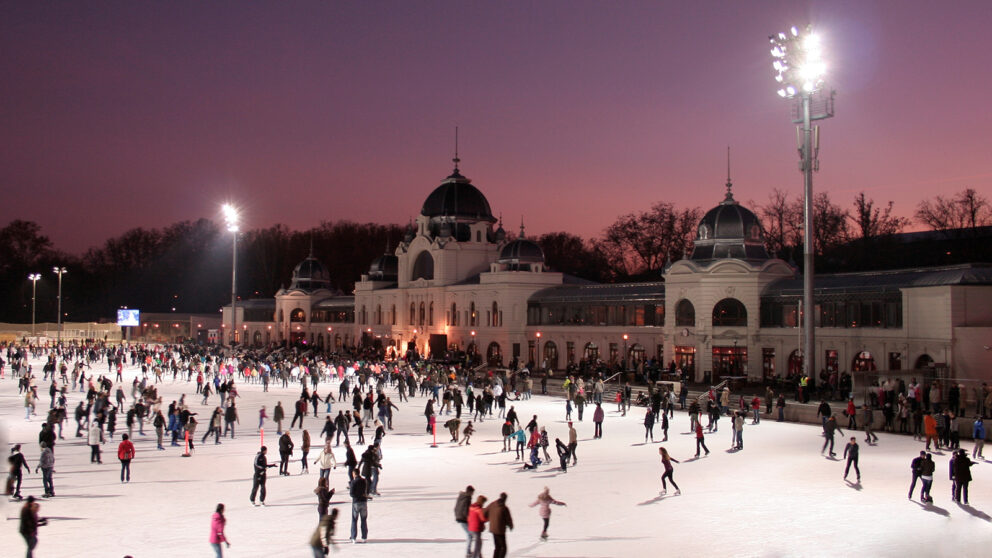 Hundreds of people ice skating at the beautiful outdoor City Park rink at dusk