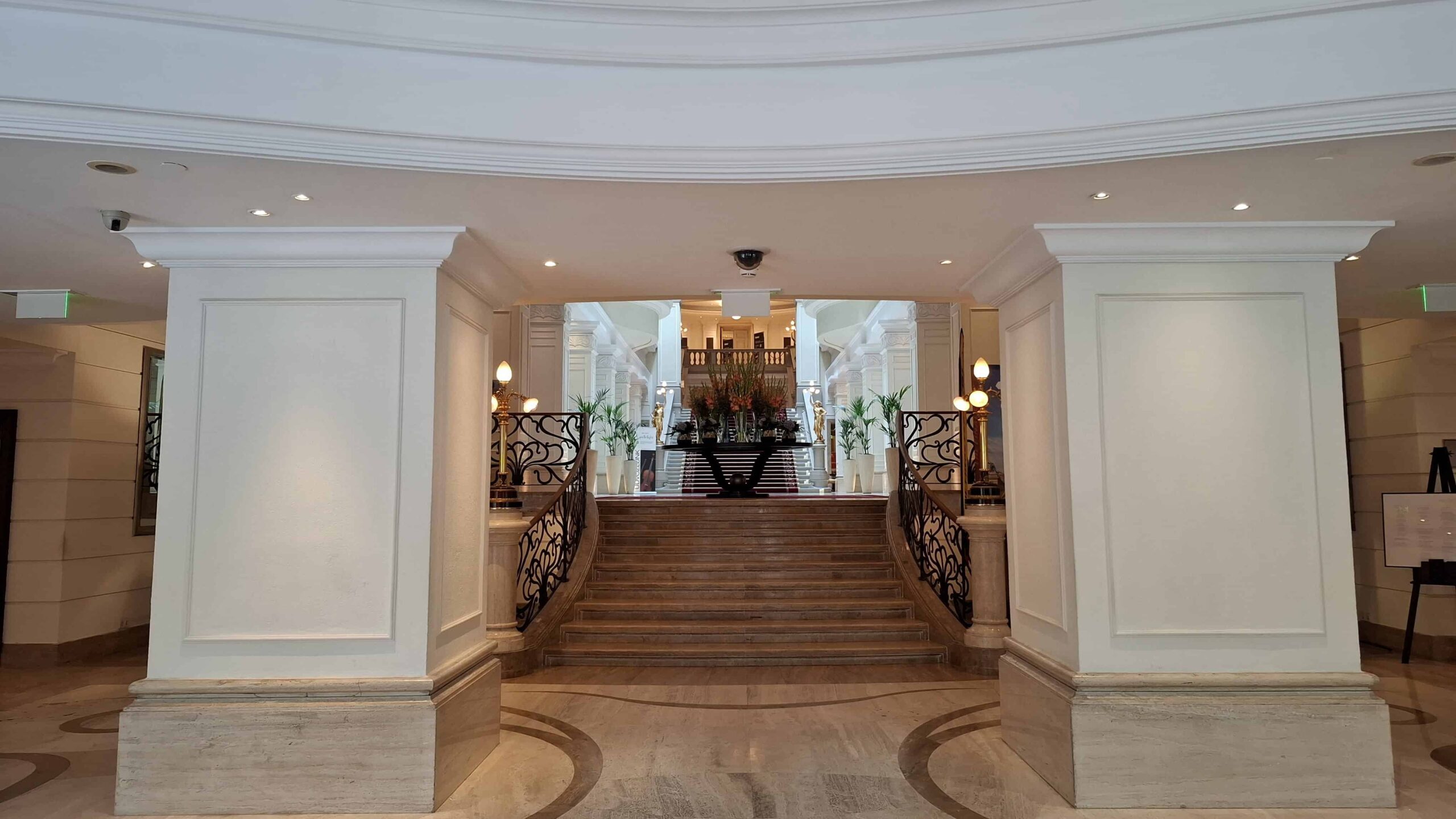 The grand marble staircase and glass atrium inside the lobby of the Corinthia Hotel