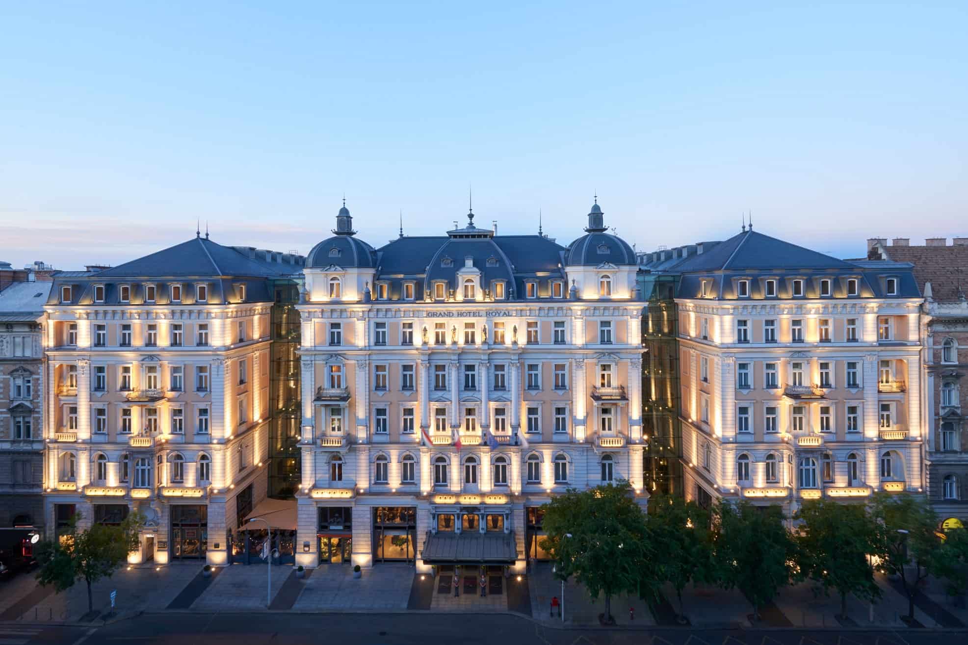 The long, heavily ornate classical stone facade of the Corinthia Hotel on the Grand Boulevard