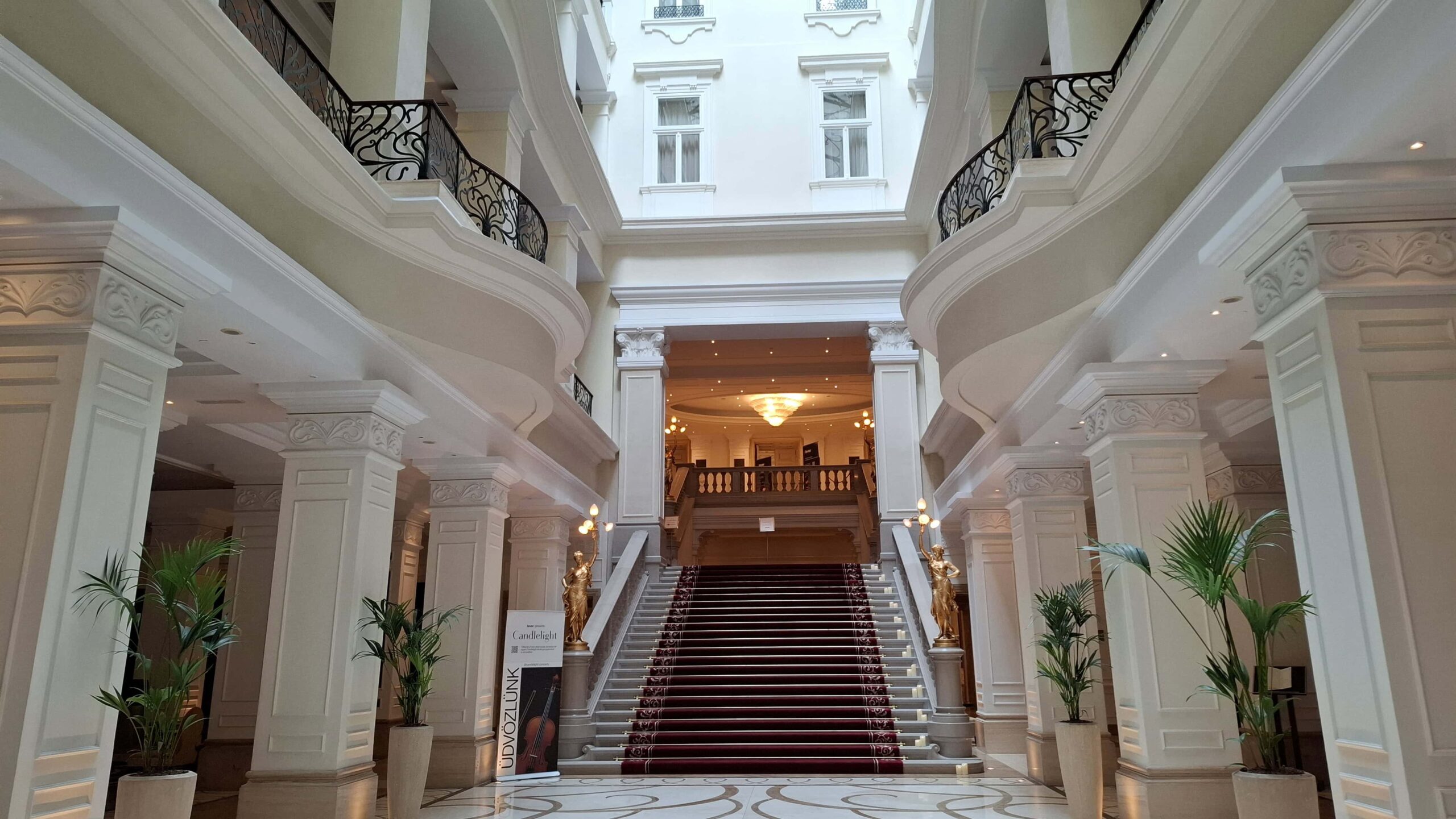 The massive, six-story glass-roofed central marble atrium inside the Corinthia Hotel