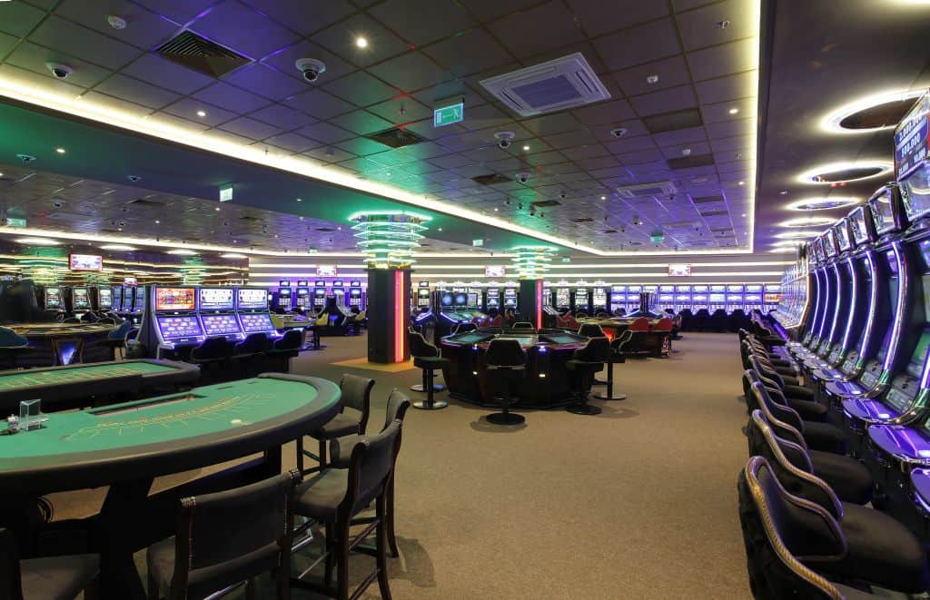 Red dice tumbling across the betting layout of a Craps table