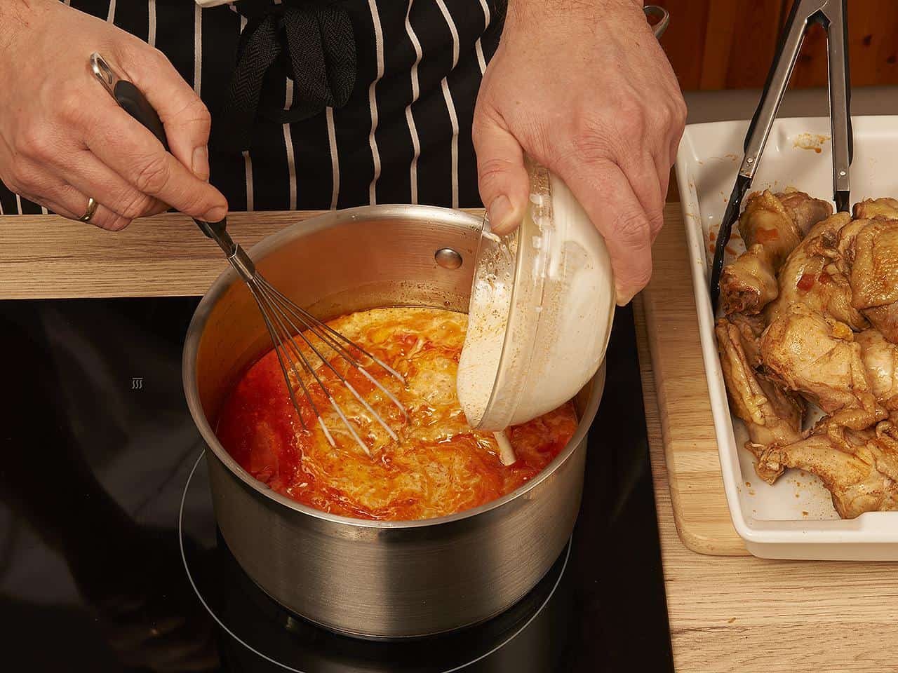 Bubbling creamy paprika sauce over chicken in a cast-iron pot