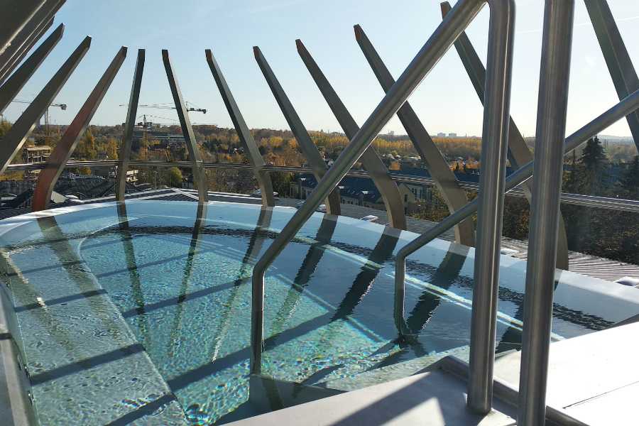 The luxurious indoor rooftop panorama thermal pool at Csillaghegyi Bath looking over the hills