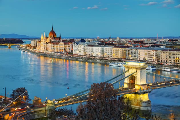 An aerial view of the Danube River showing multiple historic bridges connecting Buda and Pest