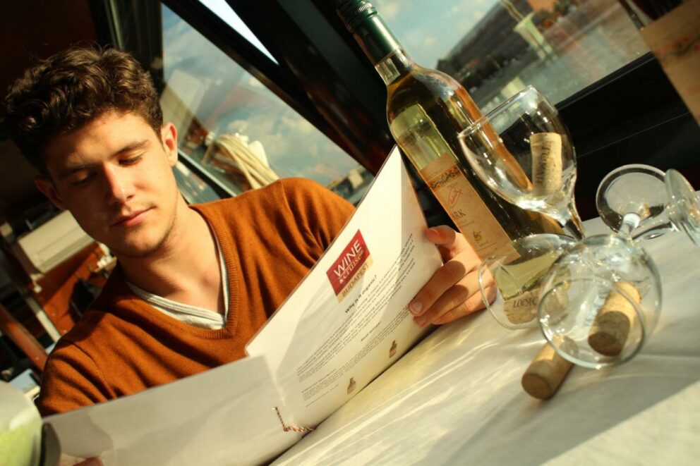 A guest reading a wine menu on a Danube river cruise
