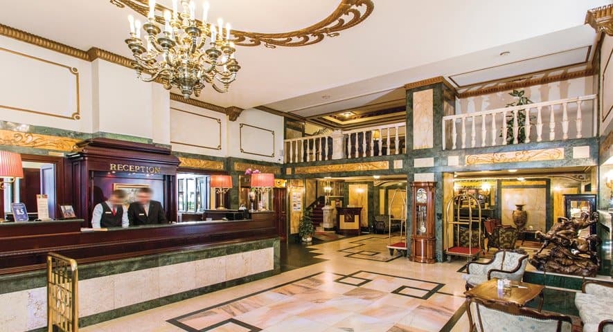 The historic, gracefully curved pale stone facade of the Danubius Hotel Astoria