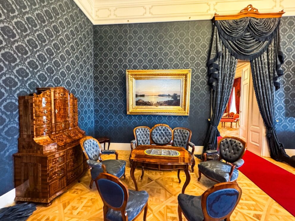 The marble fireplace and mirror in the Blue Salon