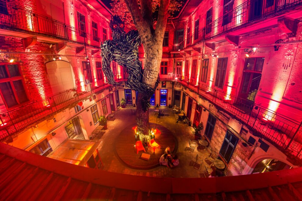 A moody hallway bathed in deep red neon lighting inside Doboz ruin pub