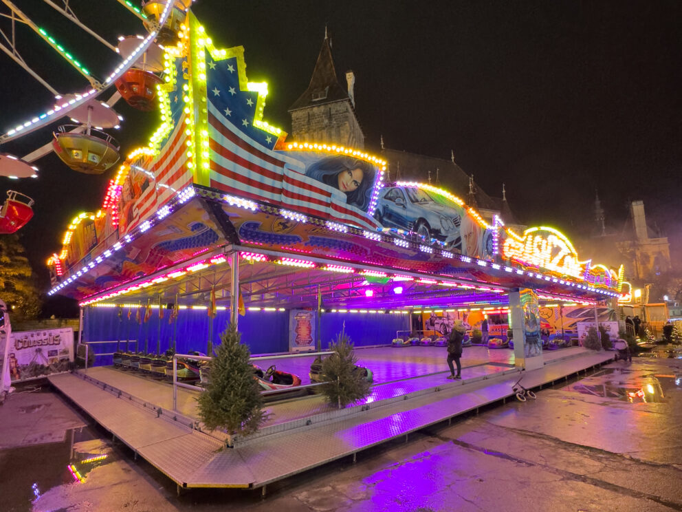 Brightly colored electric bumper cars driving around the metal floor arena