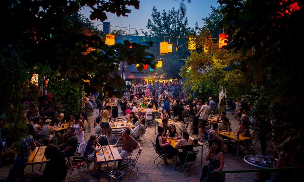 The atmospheric outdoor garden of Dürer Kert illuminated with colorful lanterns at night