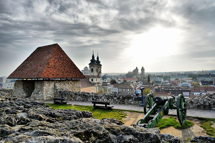 A green cannon on the walls of Eger Castle overlooking the town