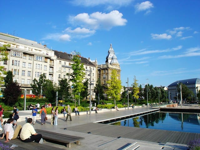 People relaxing by the reflecting pool in Erzsebet Square