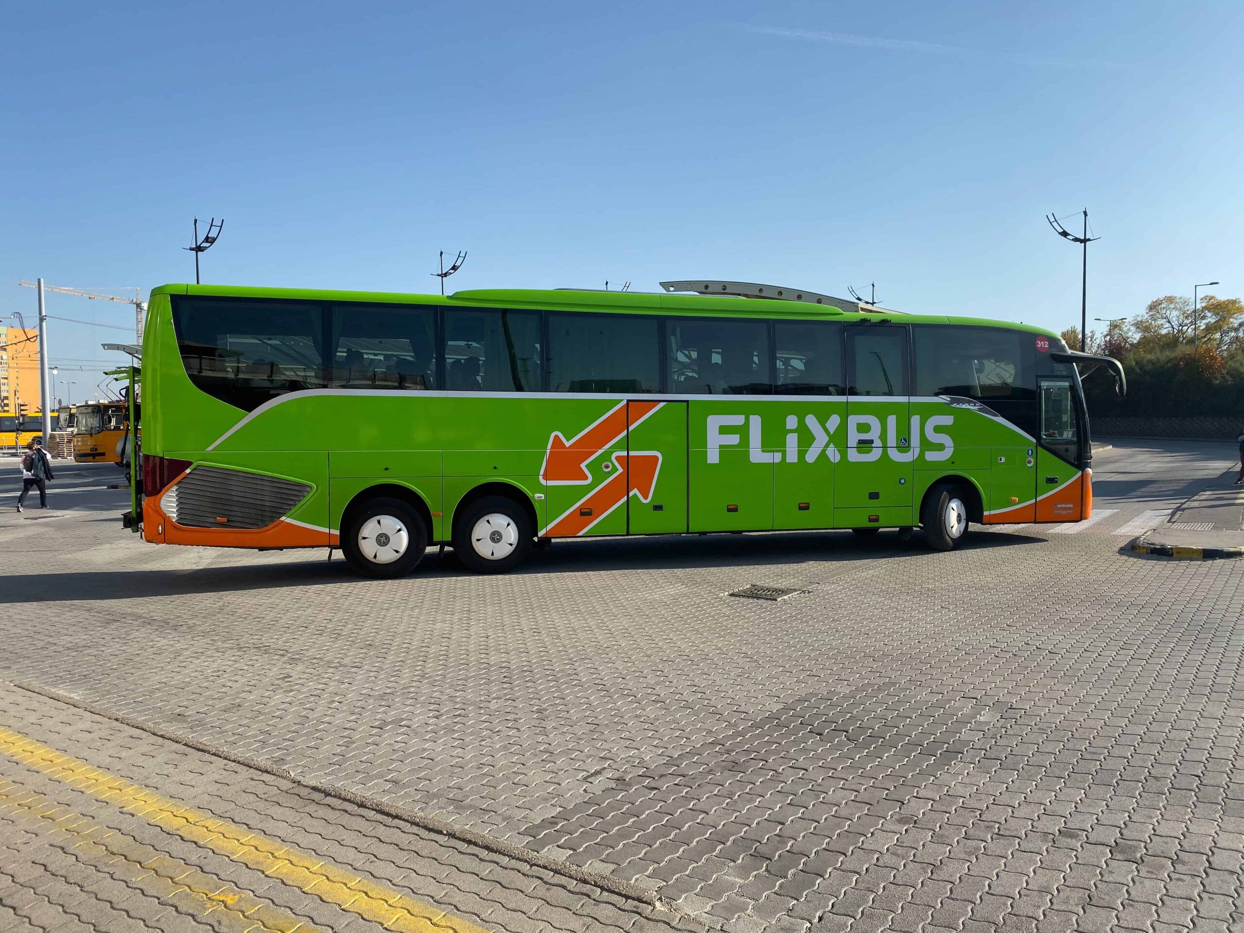 A green Flixbus arriving at the Kelenföld bus station in Budapest