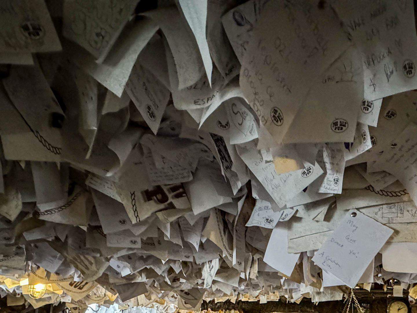 Thousands of paper notes and business cards pinned to the wooden ceiling of the pub