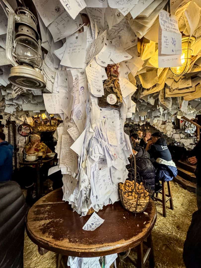 A heavy rustic wooden dining table featuring a deep basket of peanuts inside the For Sale Pub