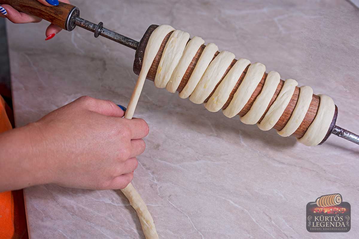 Dozens of freshly baked chimney cakes arranged on wooden pegs in a shop window