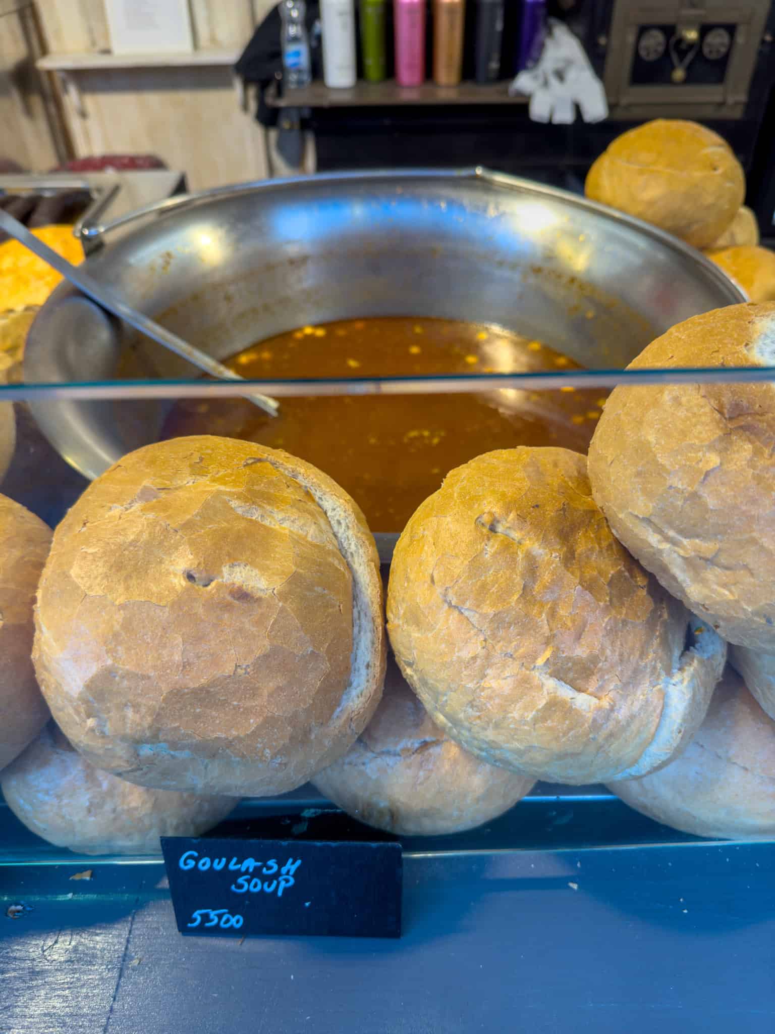 Large, round bread bowls prepared for serving authentic Hungarian goulash soup at the Basilica Christmas market.